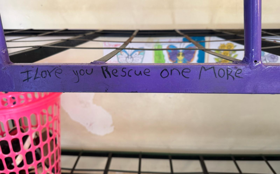 Metal bunk bed frame with the words I Love You Rescue One More written on it.