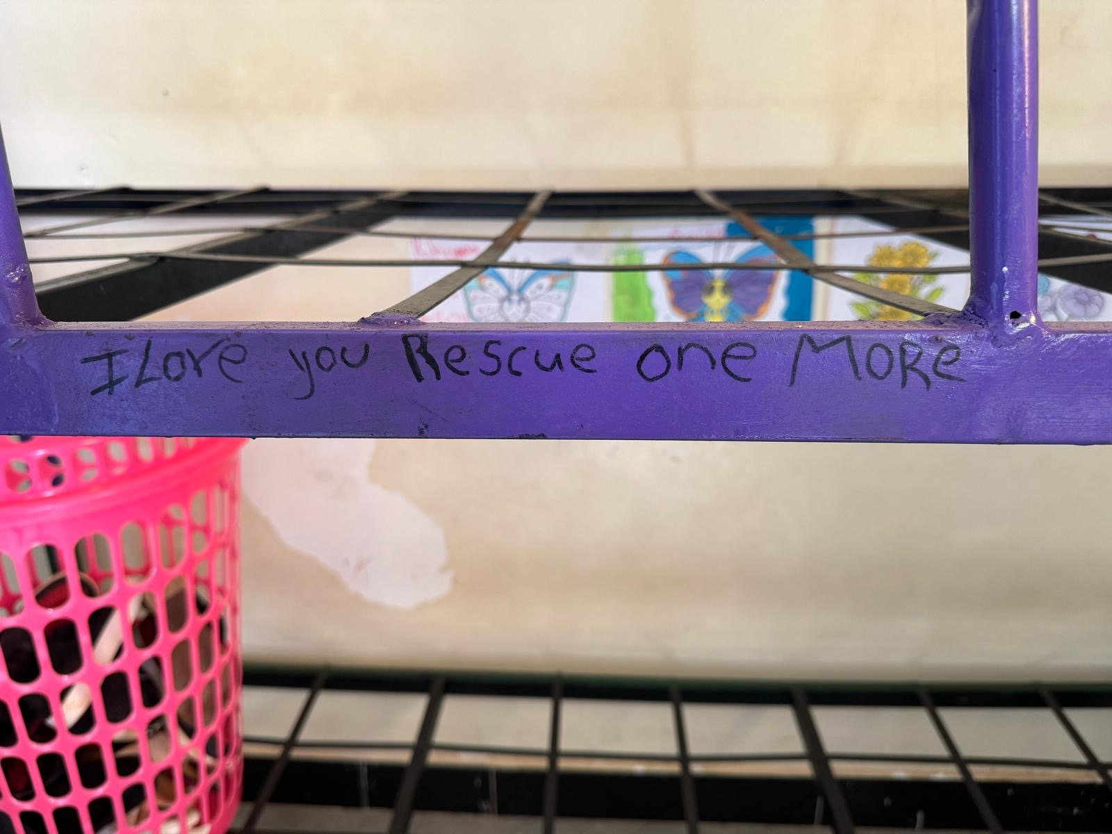 Metal bunk bed frame with the words I Love You Rescue One More written on it.